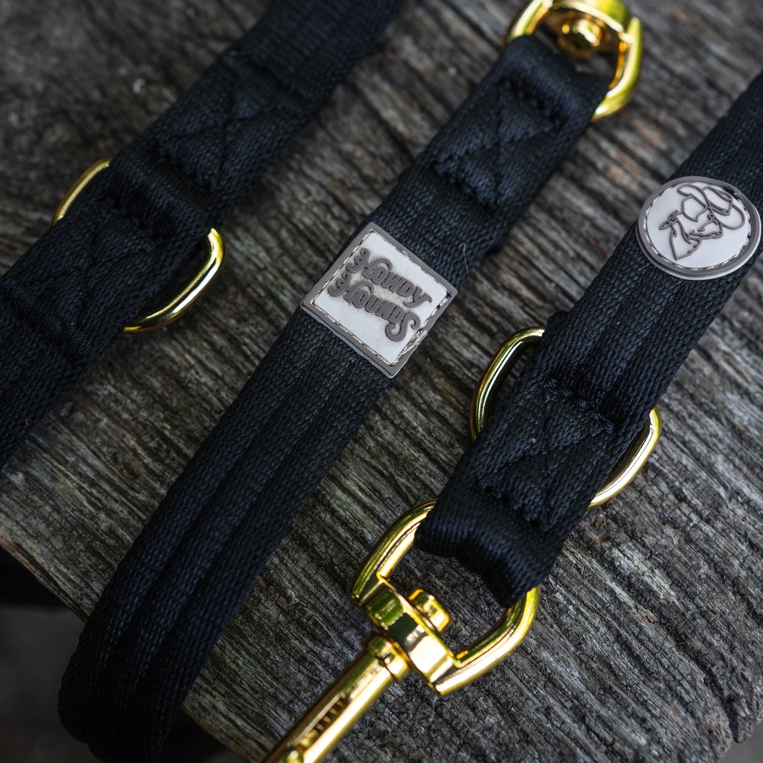 Black dog leash with gold hardware on a textured surface