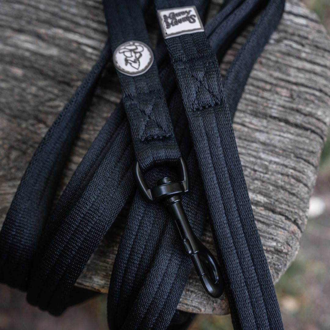 Black leather strap with a metal buckle on a textured surface