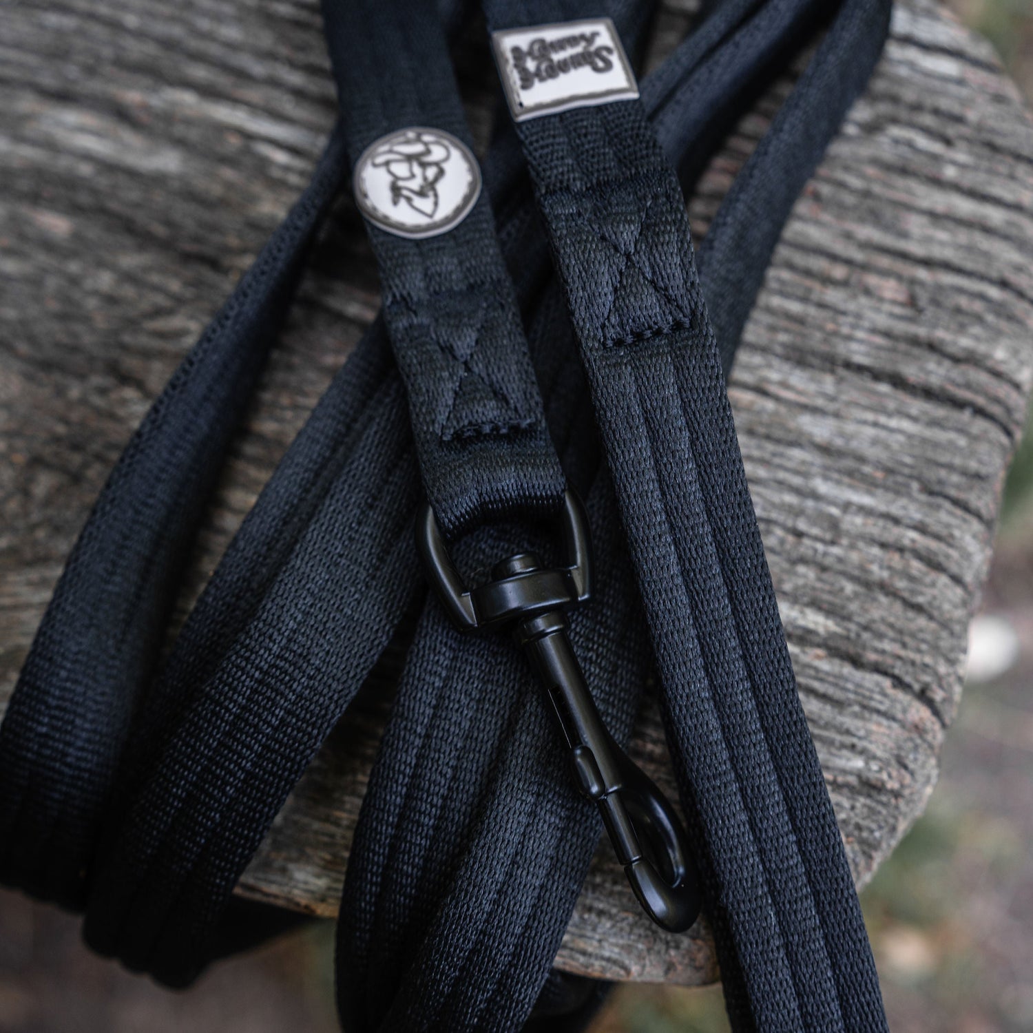 Black leather strap with a metal buckle on a textured surface