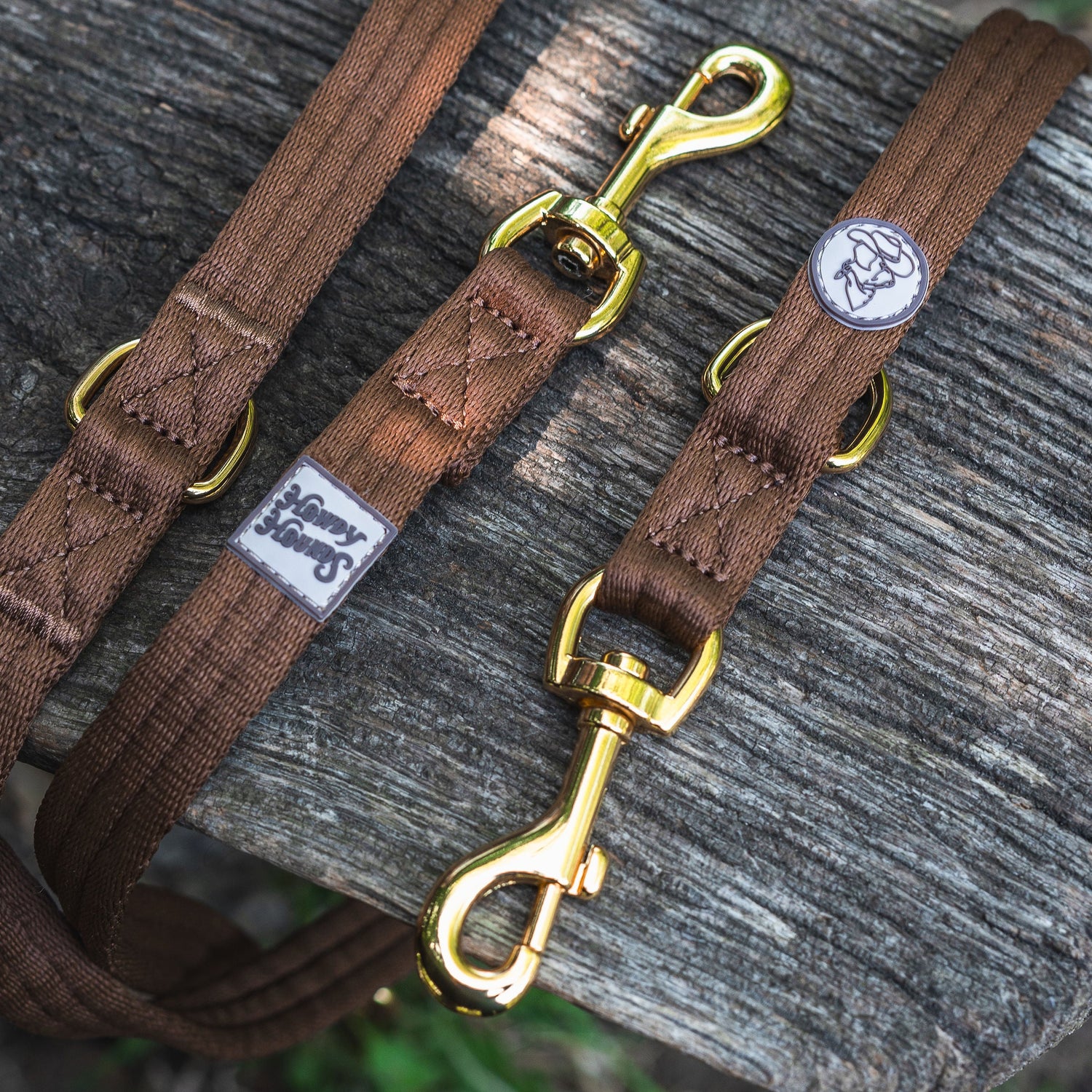 Brown dog leash with gold clasp on a wooden surface